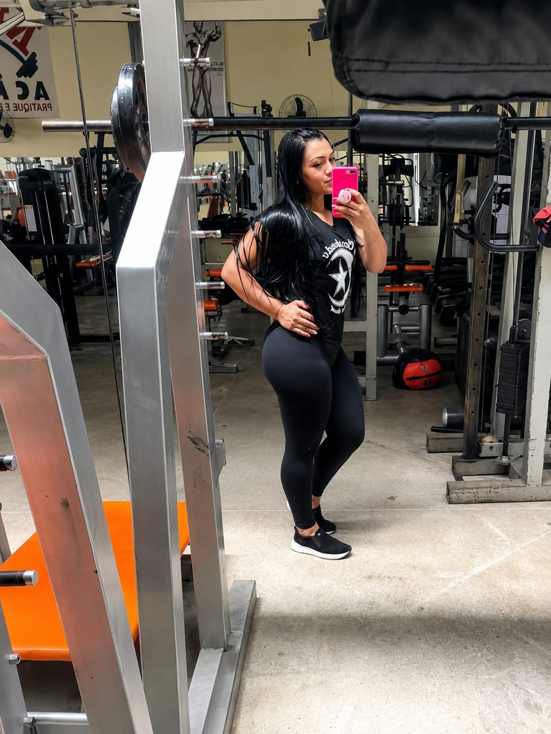 Aluna posando na área de peso livre da Max Academia